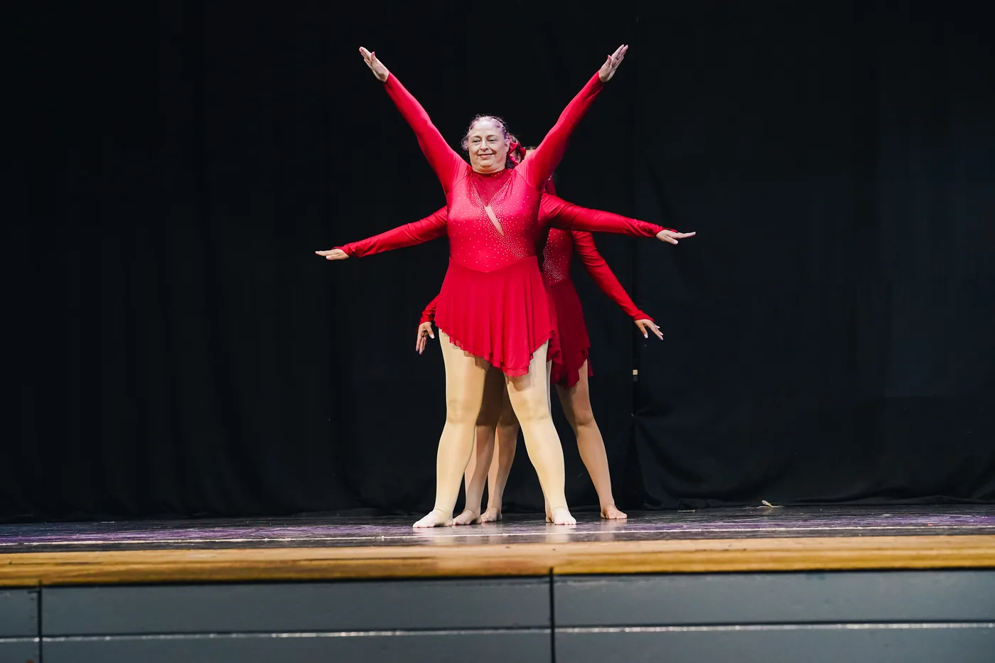A trio performing in red costumes